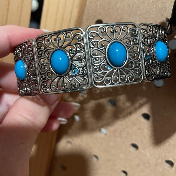 Large stretchy silver bracelet with silver squares and blue oval centers.
